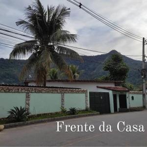 un palmier en face d'un bâtiment avec garage dans l'établissement Le Partie, à Angra dos Reis
