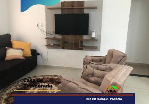 a living room with a brown couch and a television at Casa maravilhosa c/piscina bourb in Foz do Iguaçu