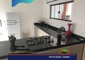 uma cozinha com um fogão e uma bancada em Casa maravilhosa c/piscina bourb em Foz do Iguaçu