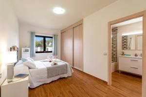 a white bedroom with a bed and a window at Villa Fakay by Villa Plus in Caleta De Fuste