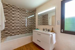 a bathroom with a sink and a tub and a mirror at Villa Fakay by Villa Plus in Caleta De Fuste +14 photos
