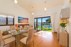 a dining room and living room with a table and chairs at Villa Fakay by Villa Plus in Caleta De Fuste