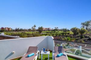 a balcony with chairs and a view of the desert at Villa Fakay by Villa Plus in Caleta De Fuste