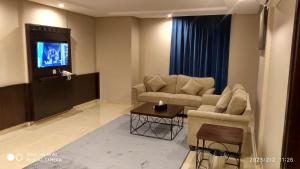 een woonkamer met 2 banken en een televisie bij Yan Apartments in Jeddah