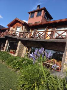 Casa grande con balcón y flores púrpuras en Posada Agua Pampas en Villa Ventana