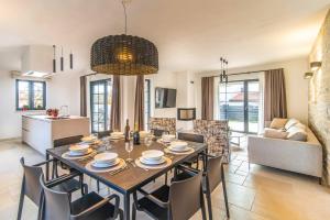 een eetkamer en een woonkamer met een tafel en stoelen bij Villa Prodol by Villa Plus in Manjadvorci