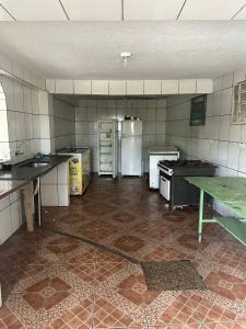 een lege keuken met een koelkast en een tafel bij Chacara dos oliveiras in Sao Paulo