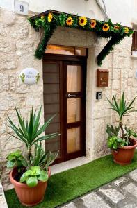a house with two potted plants in front of a door at Tama67 suite in Ostuni