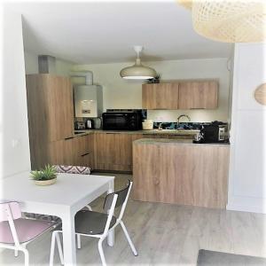 eine Küche mit einem weißen Tisch und Stühlen in einem Zimmer in der Unterkunft Azurea - Charmant appartement à Andernos-les-Bains in Andernos-les-Bains