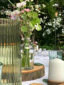 un jarrón con flores en él sentado en una mesa en Hotel Au Nom De Dieu, en Dilsen-Stokkem