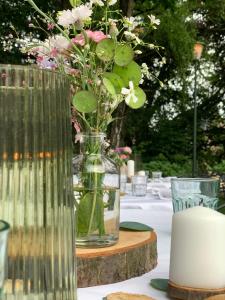 a vase with flowers in it sitting on a table at Hotel Au Nom De Dieu in Dilsen-Stokkem