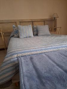 1 cama grande con sábanas y almohadas azules en Leonidas apartments en Mendoza