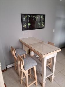 mesa de madera con 2 sillas, mesa y TV en Leonidas apartments en Mendoza