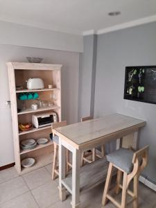 una mesa y sillas en una cocina con estantería en Leonidas apartments en Mendoza