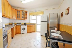 a kitchen with wooden cabinets and a white refrigerator at K - ViewPoint of Lagos GuestHouse in Lagos