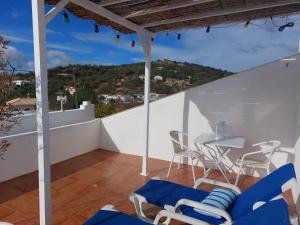 a balcony with blue chairs and a table at "Casa Oliveiras" studio avec terrasse et piscine in Loulé