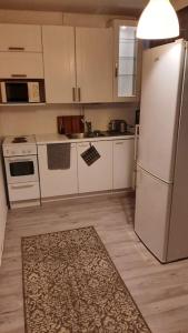 uma cozinha com electrodomésticos brancos e um tapete no chão em Huoneisto noin 55m2 perusvarustein. 
