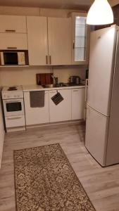 a kitchen with white appliances and a rug on the floor at Huoneisto noin 55m2 perusvarustein. in Knivsund +6 photos