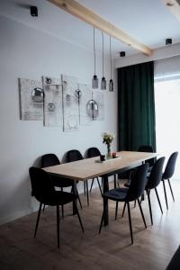 a dining room with a wooden table and chairs at Dom przy molo in Augustów