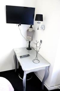 a white desk with a monitor and a lamp on it at Guesthouse Le Vauban in Neuf-Brisach