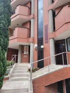 un edificio de ladrillo con una escalera delante de él en Laureles 001, en Medellín