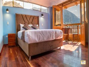 ein Schlafzimmer mit einem großen Bett und einem großen Fenster in der Unterkunft Pisonay Hotel in Pisac