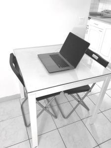 un ordenador portátil sentado en una mesa blanca en Studio Apartment near to Paris, en Créteil