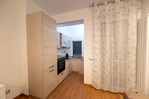 a kitchen with white cabinets and a door with a window at n&ghomesweethome RaffaelloElegante appartamento ideale casa vacanze affari in Milan