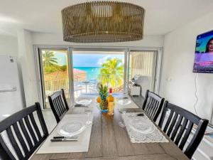 a dining room with a table with a view of the ocean at Kokonut Sea view Beach Front Pool Central Garage in Grand Case