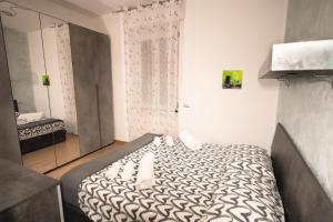Dormitorio pequeño con cama y espejo en RaffaelloElegante appartamento ideale casa vacanze affari, en Milán