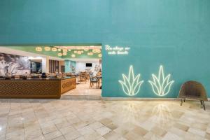 瓦哈卡德華雷斯的住宿－瓦哈卡嘉年華酒店，一间有蓝墙的餐厅,里面种有植物