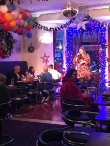 a woman standing on a stage in a restaurant at Belmont Hotel in Blackpool