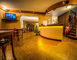 een lobby met een gele muur en een eetkamer bij Logis Hotel Restaurant la Corniche des Cevennes in Saint-Jean-du-Gard