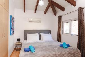 a bedroom with a bed with blue pillows on it at Renthub Villas at Kolympia in Kolimbia +46 photos