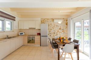 a kitchen and dining room with a table and chairs at Renthub Villas at Kolympia in Kolimbia