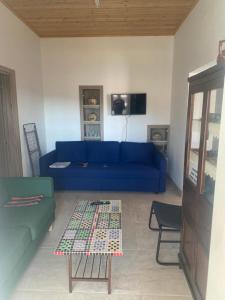 - un salon avec un canapé bleu et une table dans l'établissement TheonikosHouse, à Agros