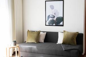 a living room with a gray couch with pillows at CA' GIALLA 2 - sul Lago di Lugano, self check-in e parcheggio - in Cadegliano Viconago