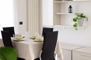 a dining room table with a white tablecloth and black chairs at CA' GIALLA 2 - sul Lago di Lugano, self check-in e parcheggio - in Cadegliano Viconago