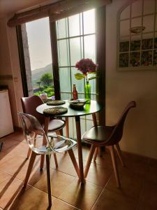 mesa y sillas en una habitación con ventana en El Somadero B en Fuencaliente de la Palma