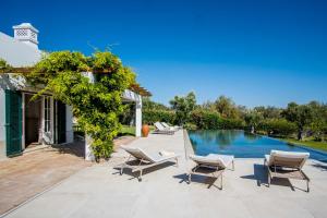 an outdoor patio with chairs and a swimming pool at Charmante villa Authentique in Loulé