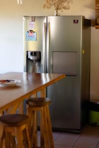 eine Küche mit einem Tisch und einem Kühlschrank aus Edelstahl in der Unterkunft casa con vista al lago in San Carlos de Bariloche