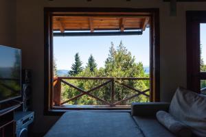 Habitación con ventana y vistas a los árboles. en casa con vista al lago en San Carlos de Bariloche