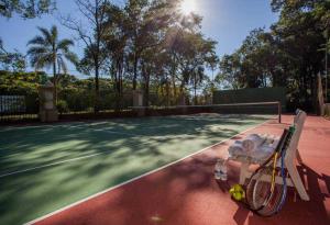 una raqueta de tenis y pelotas sentadas en una pista de tenis en Sanma Hotel en Foz do Iguaçu