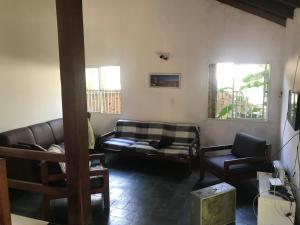 a living room with a couch and two chairs at Casa em Camburi in Camburi