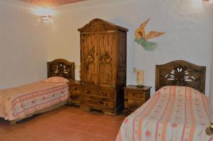 1 dormitorio con 2 camas y armario de madera en Casa Centeopan, en Amatlán