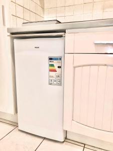 einen weißen Kühlschrank in einer Küche neben einer Theke in der Unterkunft Studio Apartment near to Paris in Créteil