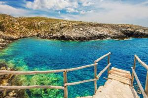 a stairway leading to a beach with blue water at Agios Leon Apartment 2 in Agios Leon