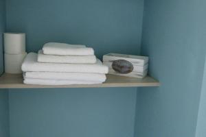 a shelf with towels and a clock on it at Agios Leon Apartment 2 in Agios Leon