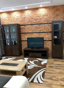 a living room with a television and a brick wall at Messe Büro in Nuremberg