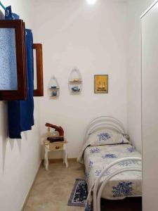 a small bedroom with a bed and a table at Sant Antioco, la vista sulla laguna Q2127 in SantʼAntìoco